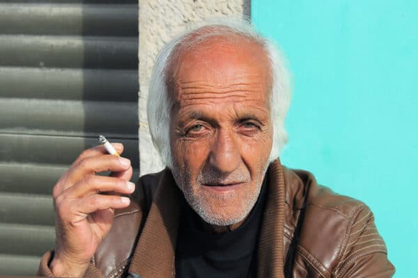 older man with white hair smoking a cigar
