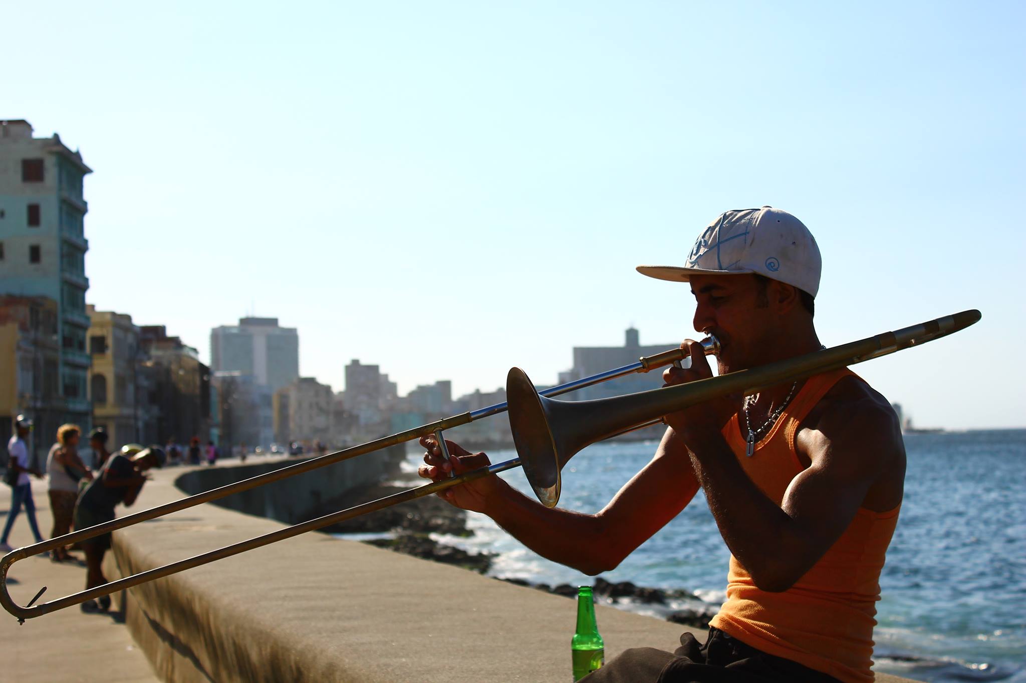 Young man playing the trumpet on a canal